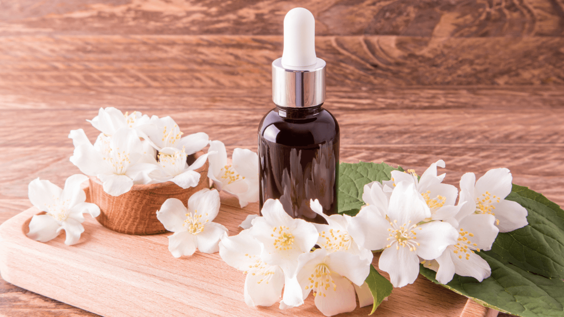 Brown dropper bottle surrounded by jasmine flowers